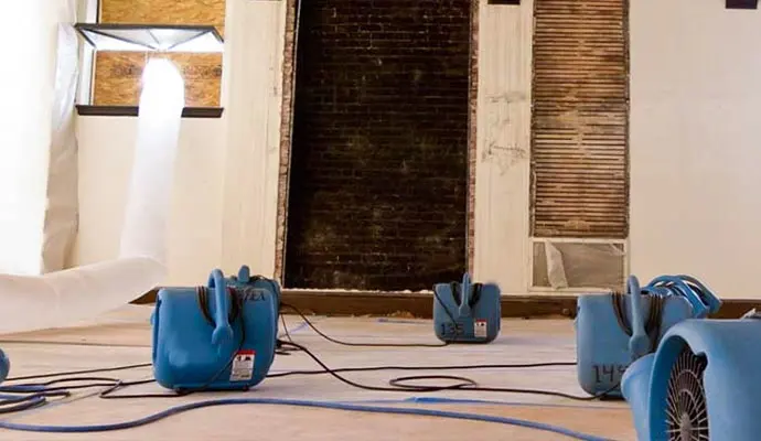 Air movers drying a room after water damage
