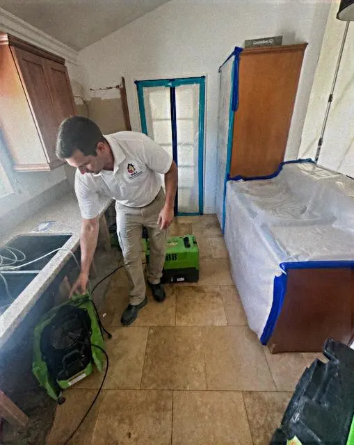 A technician setting containment during a dry-out